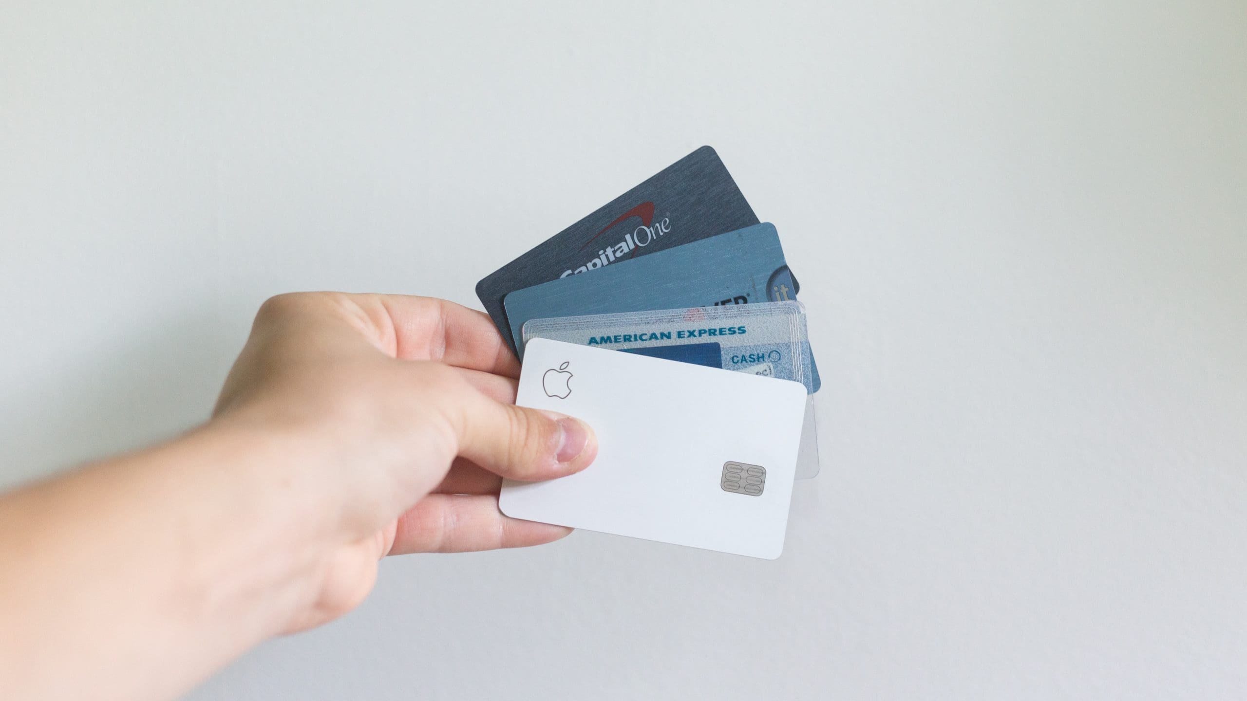 Image shows a hand holding multilpe credit cards to ask the question Should authors use Square?