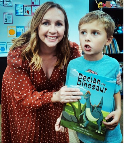 Amber Link shows off Declan the Dinosaur with a young reader.