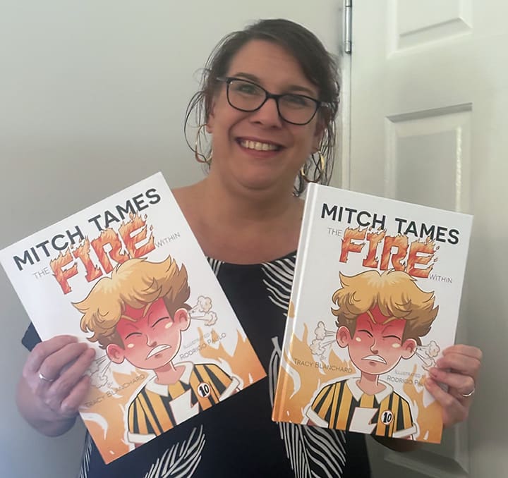 Australian author Tracy Blanchard holds her picture book, Mitch Tames the Fire Within.