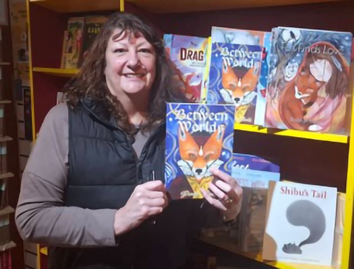 UK-based author Roselyn Barks Snead holds her second book, Between Worlds